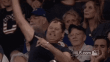 a man is sitting in the stands at a baseball game wearing a indians shirt .