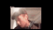 a blurry picture of a man wearing a hat and headphones .