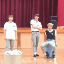 a group of young men are standing next to each other on a stage in a gym .