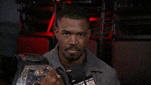 a man is holding a wrestling championship belt and saying so watch ya step .