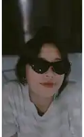 a girl wearing sunglasses and a white shirt