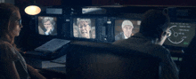 a man and a woman are sitting in front of a monitor that says tc on it