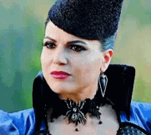 a pixelated image of a woman wearing a hat and a spider necklace