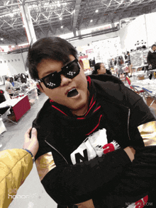 a man wearing sunglasses and a shirt that says n