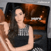 a woman in a black and white dress is sitting in the back seat of a car with the name yosra written above her