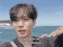 a young man taking a selfie with the words vote for kim junseo written below him