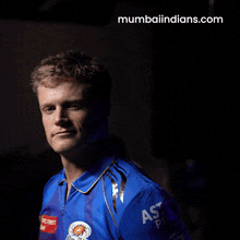 a man in a blue shirt with the website mumbaiindians.com in the corner
