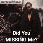 a man with a beard and sunglasses is standing in front of a crowd of people .