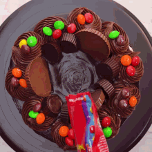 a chocolate cake with peanut butter cups and m & m 's on top