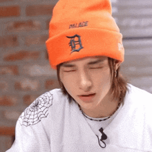 a man wearing an orange beanie and a white shirt