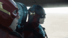 a man in a flash costume is sitting next to another man in a superhero costume