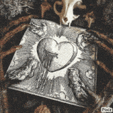 a black and white drawing of a heart surrounded by claws and a skull