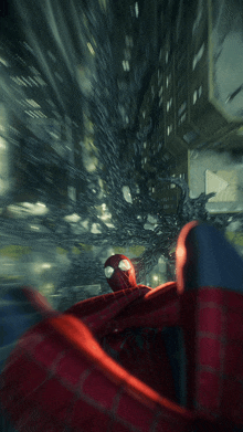 a spider-man is flying through the air in a dark city