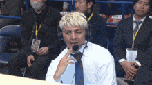 a man wearing a headset talks into a microphone in a crowd