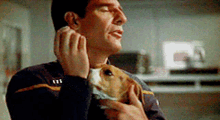 a man is holding a small dog and talking on a phone