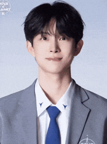 a young man wearing a suit and tie with the words boys planet k on the bottom right