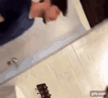 a man is standing in front of a mirror with a guitar in the foreground .