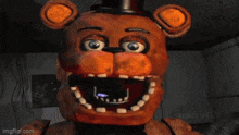 a close up of a brown stuffed animal with a purple balloon in its mouth .