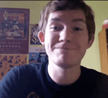 a young man is smiling in front of a poster for the album