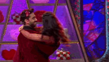 a man is holding a woman in his arms on a stage .
