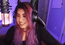 a woman with purple hair wearing headphones with horns