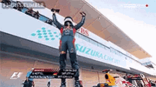a man standing on a podium with his arms in the air
