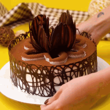 a woman with a tattoo on her wrist is decorating a cake
