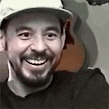 a man with a beard wearing a white hat and smiling
