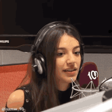 a woman wearing headphones and a microphone that says 100