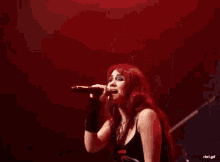 a woman singing into a microphone with the words rbd.gif in the corner