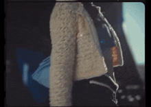a woman in a fur coat is walking with a bag