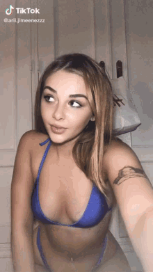a woman in a blue bikini is taking a selfie with tiktok written above her