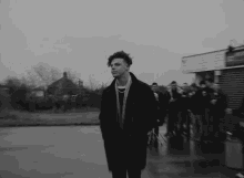 a black and white photo of a man standing in front of a group of people