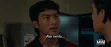a man in a red shirt is talking to another man with the words aku nentu