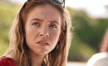 a close up of a woman wearing sunglasses making a funny face