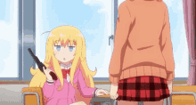 a girl in a plaid skirt holds a gun next to another girl