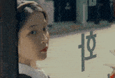 a woman looks out of a window with a foreign language written on it