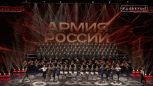 a large group of people standing on a stage with the word army in large letters behind them