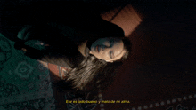a woman is laying on the floor with the words ese es lado bueno y malo de mi alma
