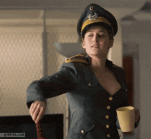 a woman in a military uniform is holding a yellow cup