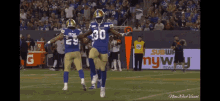 a football player with the number 30 on his jersey celebrates with his teammate