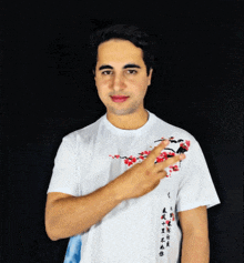 a man wearing a white t-shirt with chinese writing on the sleeve
