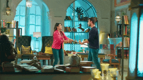 a man and a woman are standing in a living room .