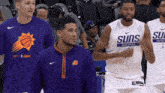 a group of basketball players with one wearing a shirt that says suns