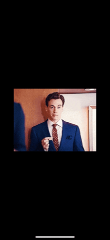 a man in a suit and tie is standing in front of a mirror .