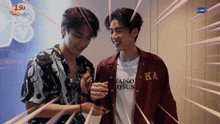 two young men are standing next to each other and one of them is wearing a ka shirt