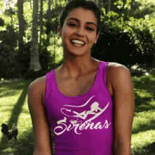 a woman wearing a purple tank top with the word sirena written on it
