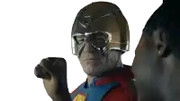 a man in a superhero costume has his fist up in the air