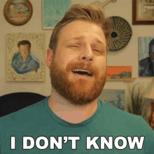 a man with a beard says i don 't know in front of paintings