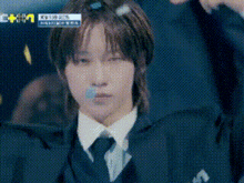 a man in a suit and tie is making a funny face with a blue tape around his mouth .